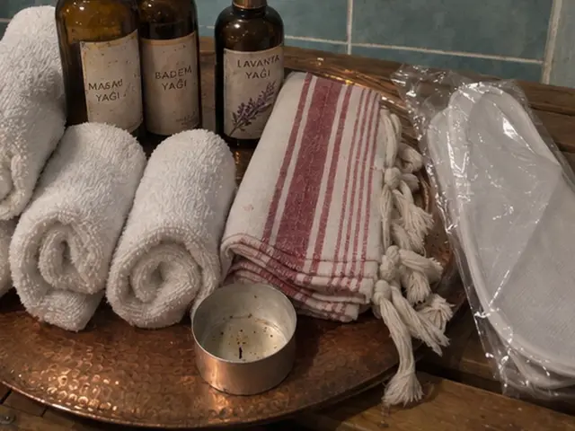 Bakır tepside rulo havlular, peştemal ve masaj yağları — Yeşilköy, Masaj Salonun